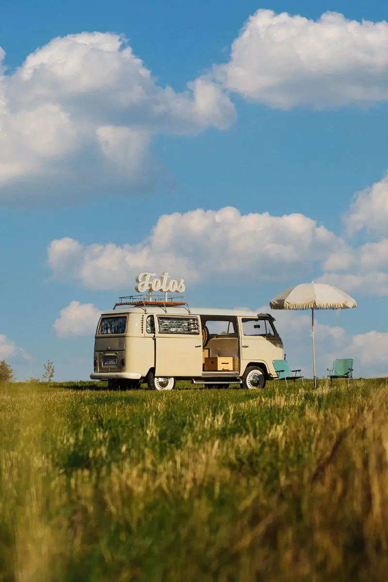 Der Bulli mit Sonnenschirm auf einem Feld