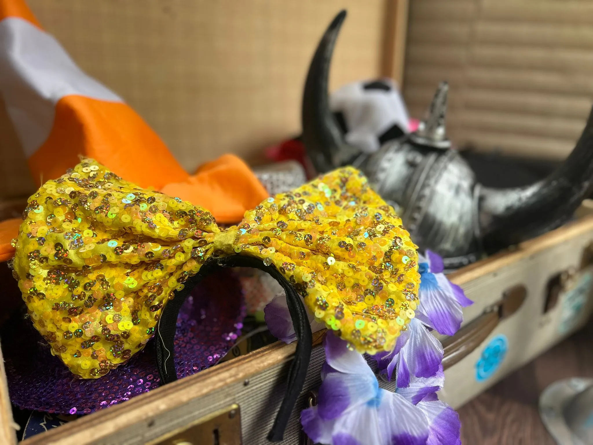 Requisiten im Bulli: goldene Pailletten-Schleife, Wikingerhelm und bunte Blütenkette