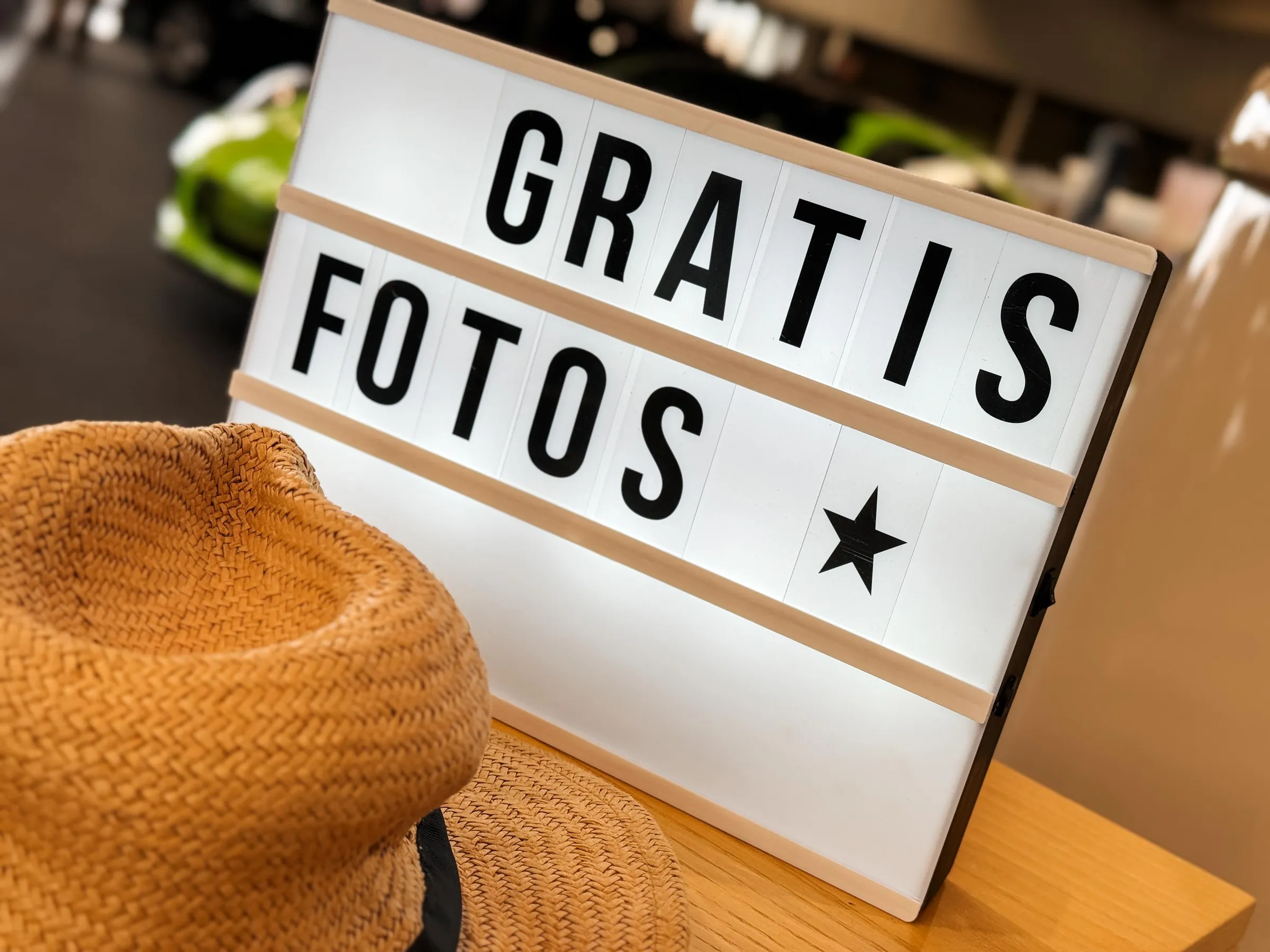 Leuchtkasten mit der Aufschrift „Gratis Fotos“ und Stern, daneben ein Strohhut aus der Requisitenkiste am Fotobulli
