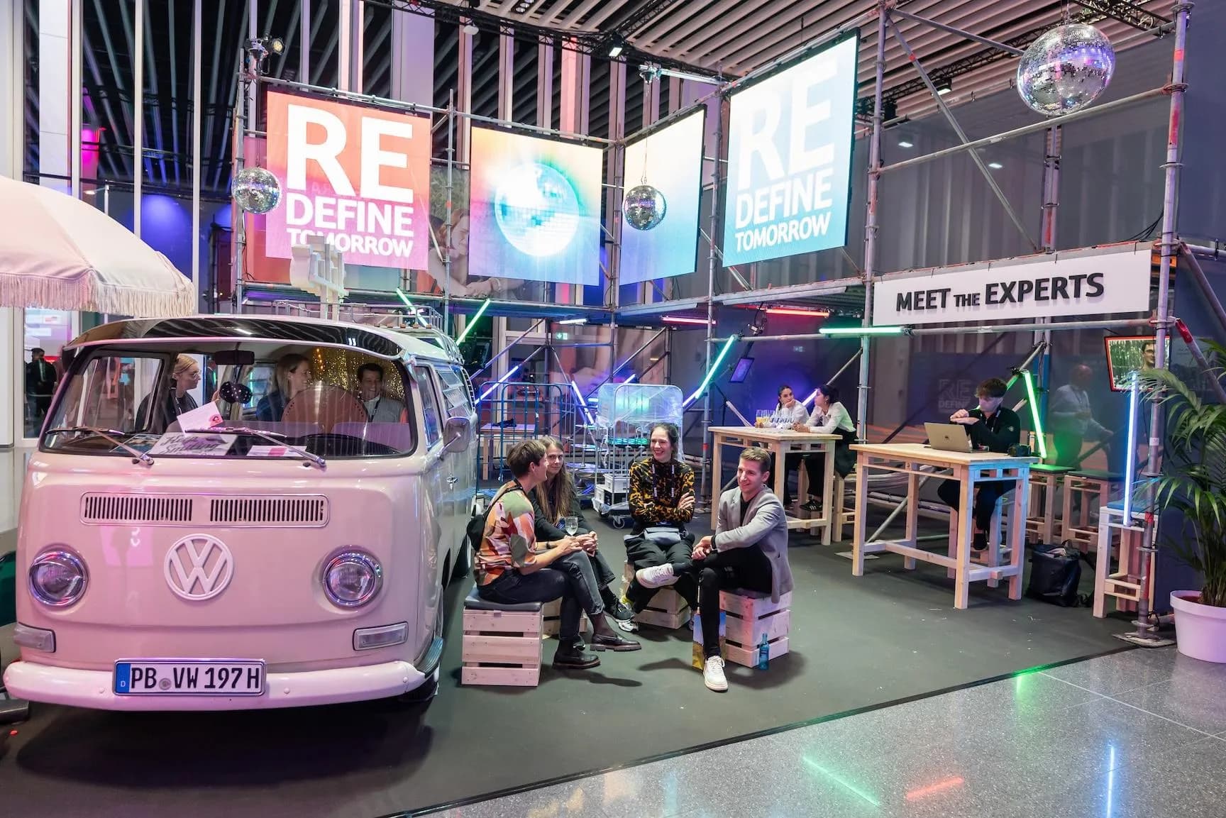Fotobulli von vorn neben einer Sitzecke mit Holzkisten am Stand „Redefine Tomorrow“ auf dem SCOPE Festival