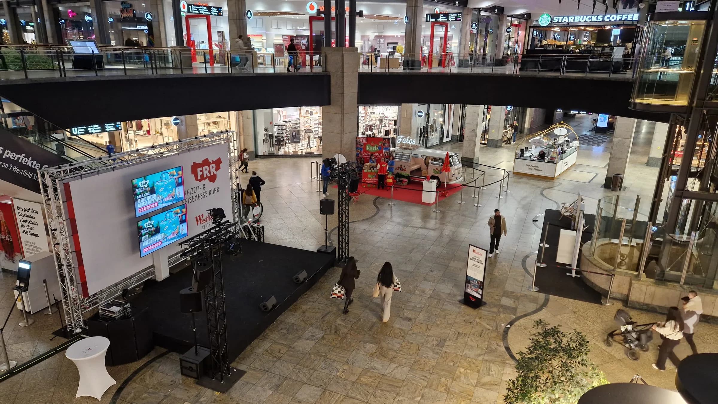 View from above of the FFR stage in the shopping centre, with the photo booth bus with Karls branding on a red carpet behind it