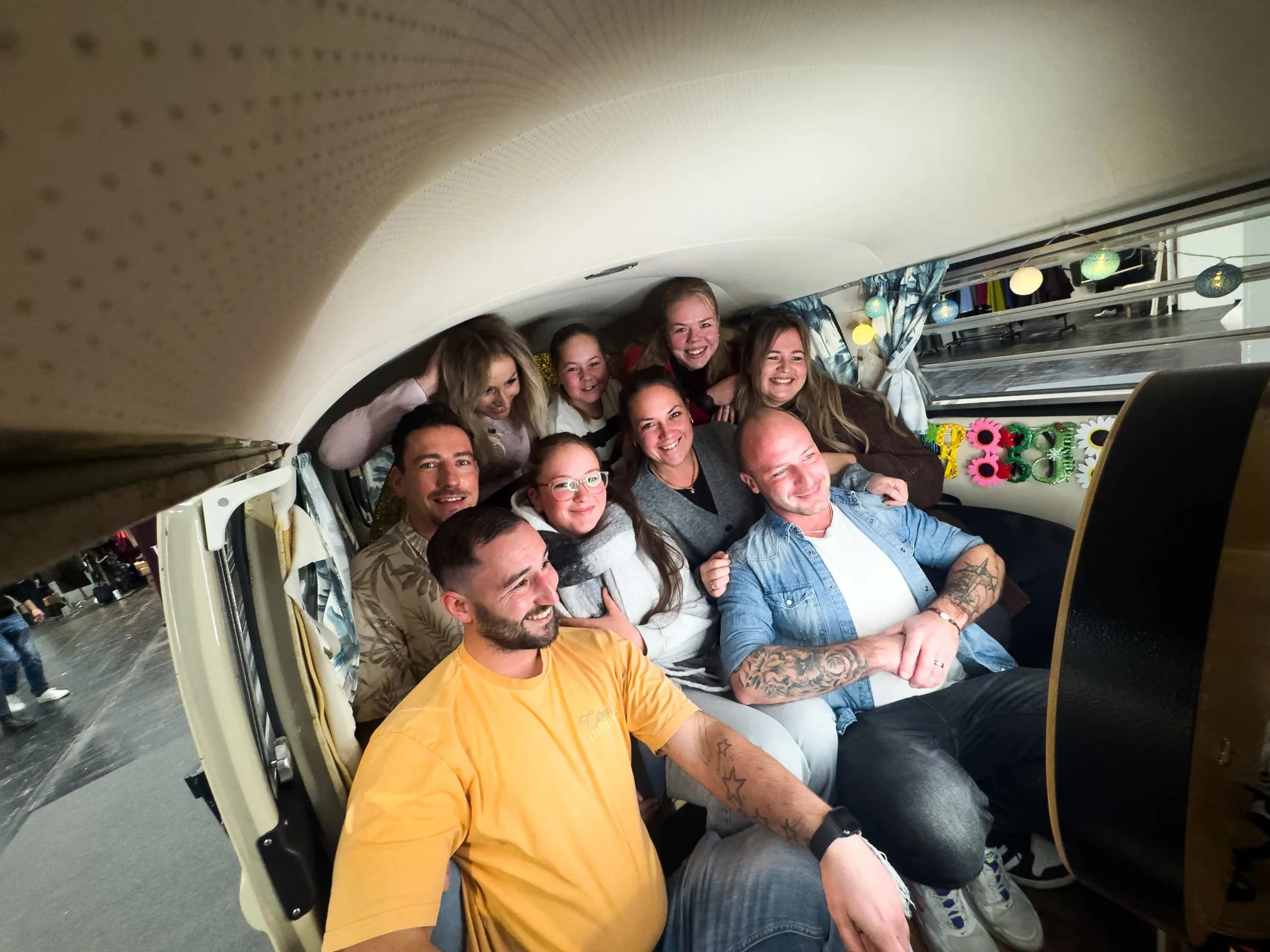 Neun lachende Gäste drängen sich im Fotobulli auf der Passion Pferd 2025 zum Gruppenfoto vor der Fotobox